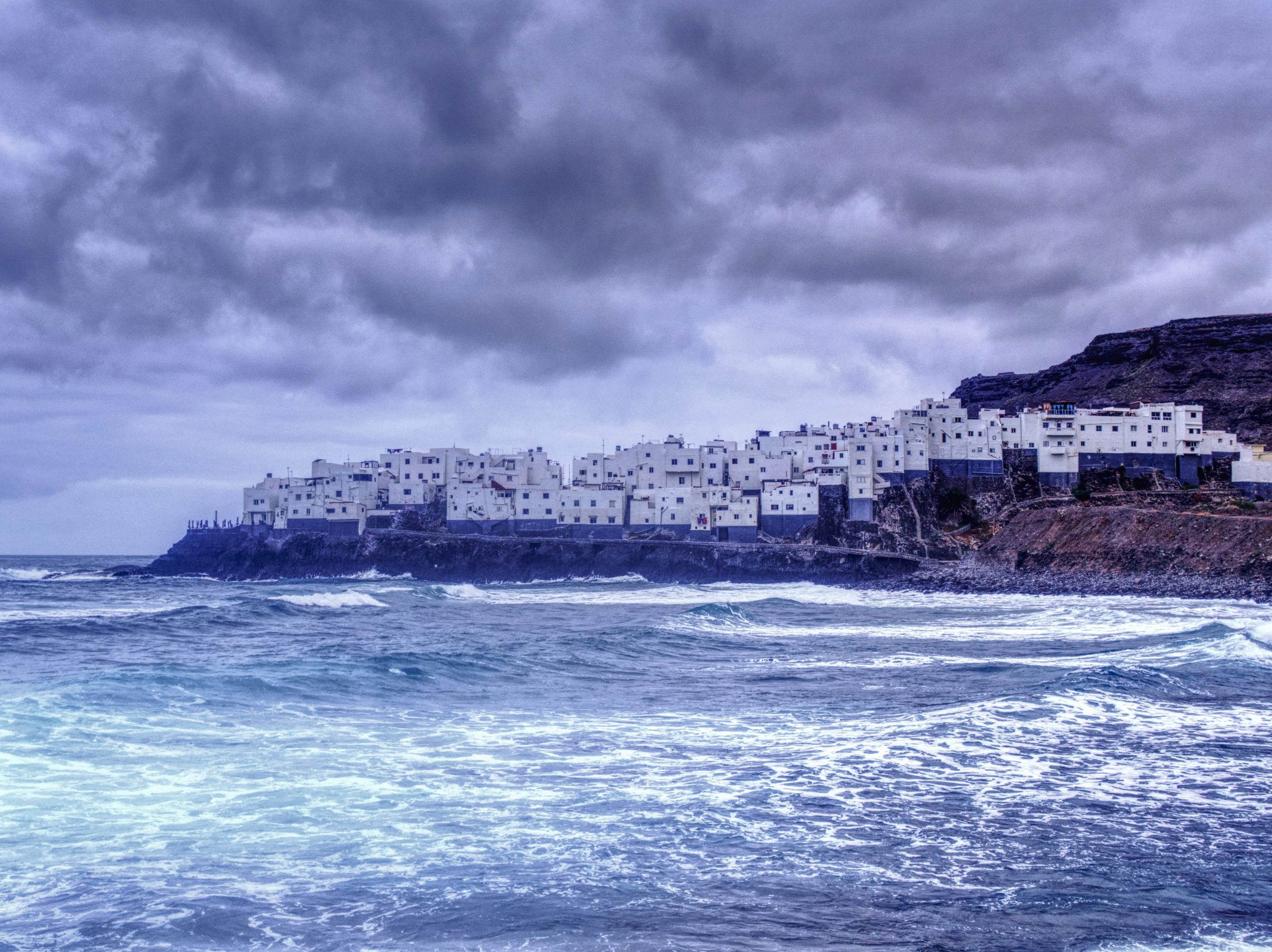 El Roque, Gran Canaria coastal village dramatically extending into the Atlantic Ocean, surrounded by rugged volcanic cliffs and deep blue water